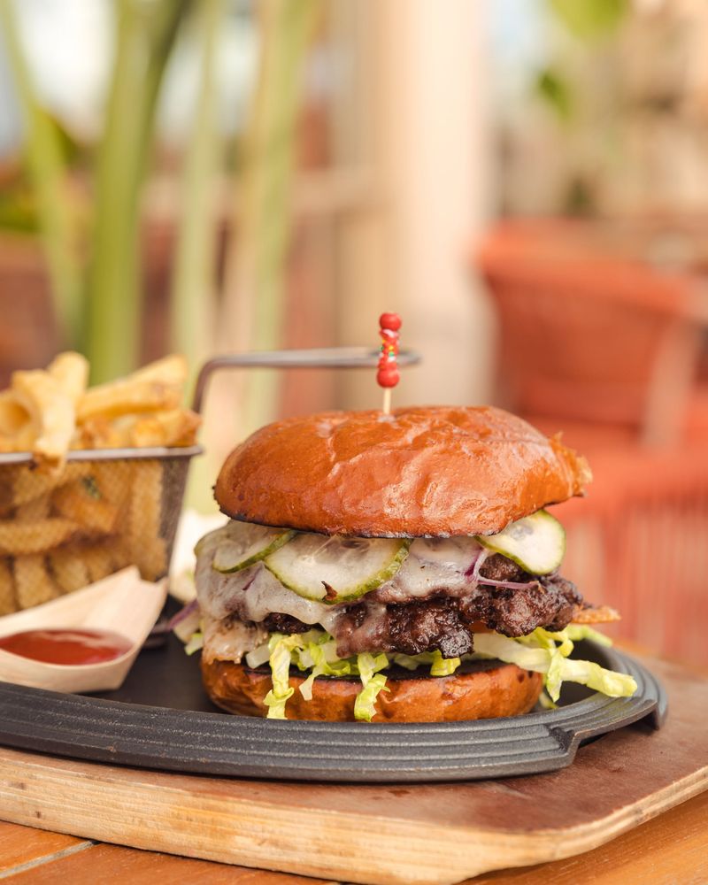 Smashed burger with melted cheese and a basket of fries