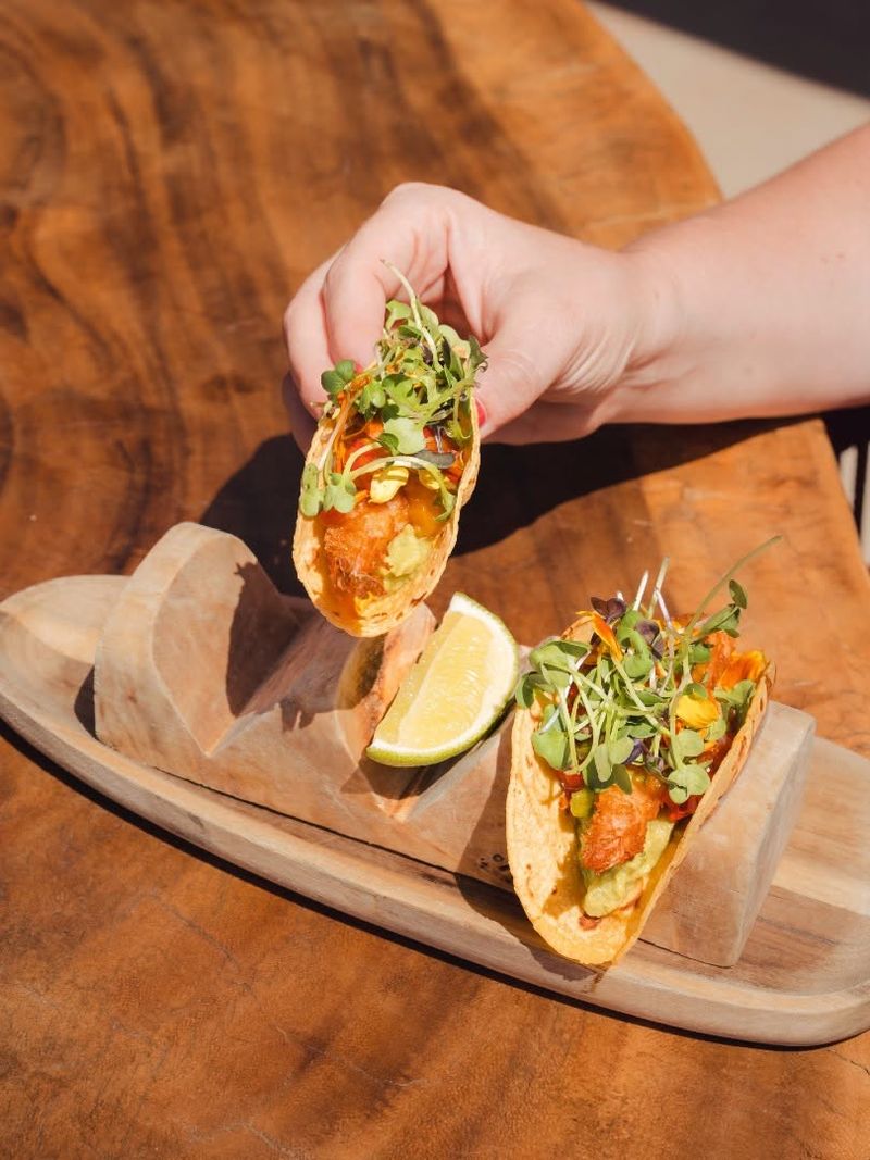 Crispy prawn tacos with lime on a wooden board